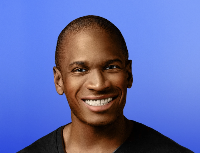 A man with a shaved head and a wide smile is shown against a blue background. The image relates to the post featuring Arthur Hayes, the BitMEX co-founder known for his crypto market commentary, pictured here as the subject discussing his warning about an AI credit bubble and its bullish crypto implications.