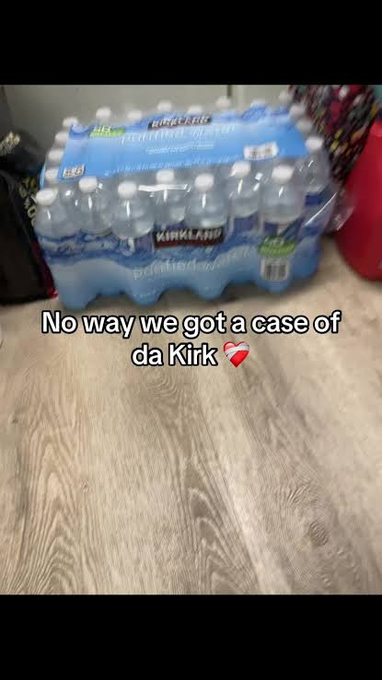 A pack of Kirkland Purified Water sits on a wooden floor with the overlaid text 'No way we got a case of da Kirk💔'.
