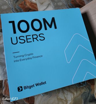 A Bitget Wallet merchandise box celebrates reaching "100M USERS," featuring the tagline "Turning Crypto Into Everyday Finance." The image shows the box from the accompanying post, which expresses gratitude for receiving this promotional item.