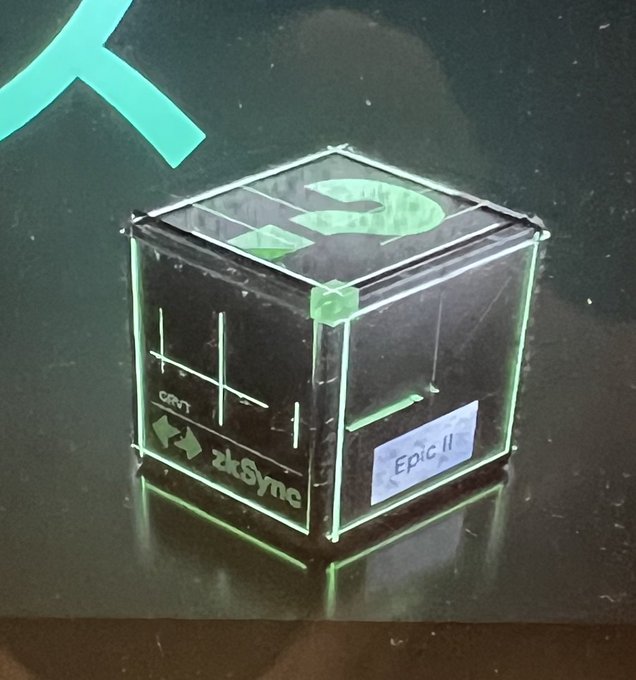 A transparent acrylic box labeled "Epic II" with "zkSync" and "GRVT" branding sits on a dark surface, reportedly tied to a $GRVT campaign where the meaning of the box remains unknown.