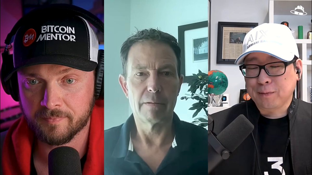The image shows three men wearing baseball caps with the words "Bits" and "Mentor" printed on them. They are standing behind microphones, suggesting that they might be participating in a podcast or radio show. The background of the image is white, which contrasts with the black and red colors of their hats.