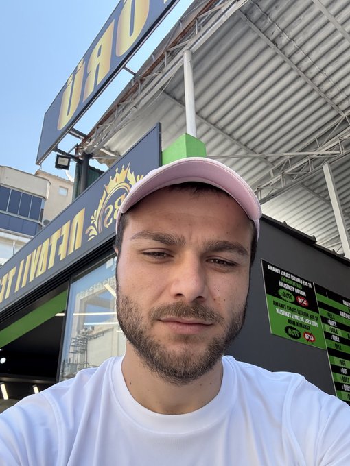 A man wearing a pink cap and white t-shirt takes a selfie outside a U-Haul rental location, with visible signage reading "TRAILERS" and "28." The "gm" (good morning) greeting pairs naturally with the casual daytime selfie vibe of starting a new day.