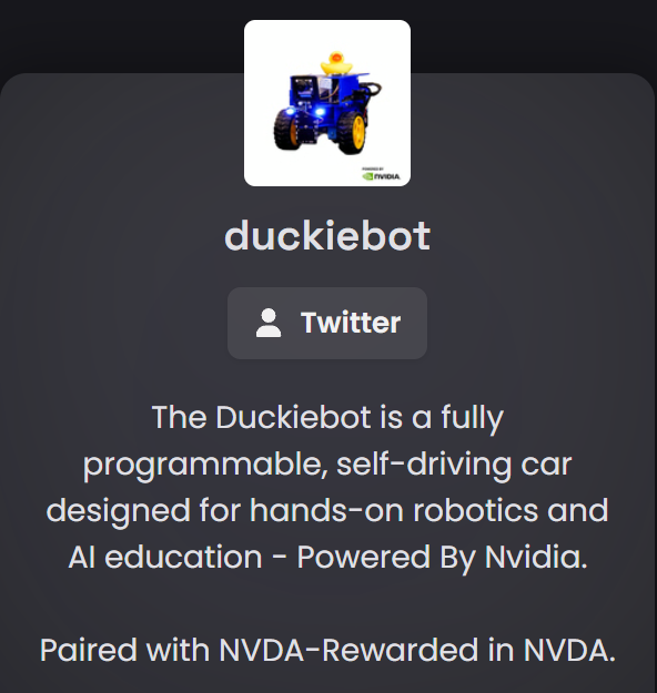 A promotional graphic for 'duckiebot' featuring an image of a small blue and yellow robotic car with a rubber duck on top, labeled 'Powered by NVIDIA'. Text describes it as 'a fully programmable, self-driving car designed for hands-on robotics and AI education – Powered By Nvidia' with a Twitter button and note that it is 'Paired with NVDA-Rewarded in NVDA.'