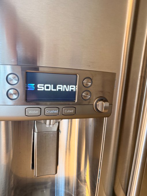 A close-up of a stainless steel refrigerator dispenser with a digital screen displaying the blue 'SOLANA' logo, with buttons labeled 'Water,' 'Crushed,' and 'Cubed' below.