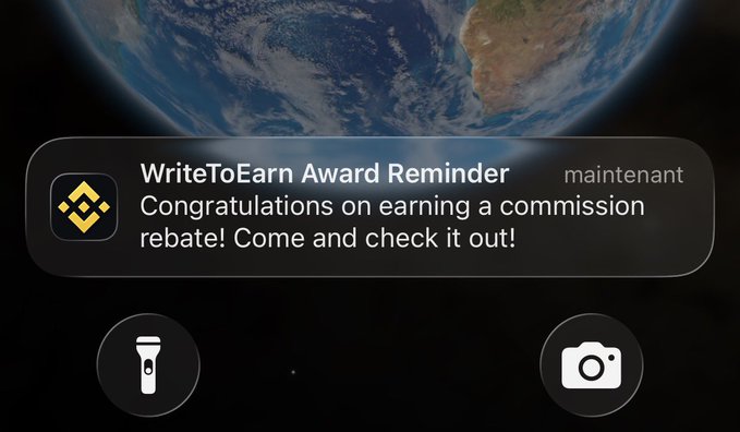 A mobile phone notification on a lock screen with an Earth wallpaper displaying a message from the Binance app: 'WriteToEarn Award Reminder - Congratulations on earning a commission rebate! Come and check it out!'