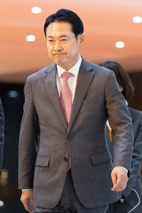 The image shows a man in a gray suit with a pink tie, appearing to be at a formal indoor venue, walking with a serious expression. Based on the accompanying post about People Power Party leader Jang Dong-hyuk's efforts regarding crypto taxation deferral, this is likely Jang Dong-hyuk himself, the politician pushing for the postponement of cryptocurrency tax implementation.