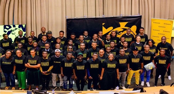 Group photo of Binance Web3 educational event attendees wearing branded Binance t-shirts.