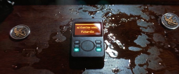 The image shows an electronic device, possibly a small computer or gaming console, placed on top of a wooden table with water droplets on its surface. The device appears to be turned off, indicating that it might not be functional at the moment. The text in the image reads "don't just buy a token. buy one that gives u actual ownership. staking my $RAWR on this." This message seems to be related to the electronic device's functionality or ownership, possibly referring to the device as an item of value rather than a simple token for buying and owning.