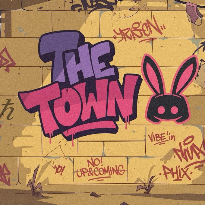 A colorful graffiti-style logo on a brick wall reads "THE TOWN" in pink and purple lettering next to a smiling pink bunny head silhouette.