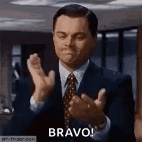 The image features a man dressed in a suit, clapping his hands together with both of them raised above his head. The text "Bravo!" is written below him, indicating that he has just made an impressive or noteworthy gesture.