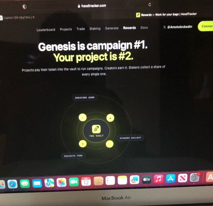 The image shows a screenshot of the hoodtracker.com website on a MacBook Air, displaying the HoodTracker platform's campaign model with the text "Genesis is campaign #1. Your project is #2." alongside a diagram illustrating how projects fund "The Vault," creators earn, and stakers collect yield. The diagram visually supports the post's description of the flywheel mechanism where projects deposit tokens, creators earn rewards, and stakers collect yield from every campaign run through the vault.