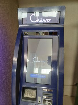 A photograph of a blue 'Chivo' branded ATM kiosk.