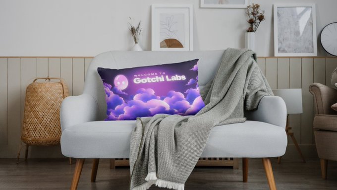 A light blue sofa sits in a living room setting with a decorative pillow that reads 'WELCOME TO Gotchi Labs' featuring a pink character over purple clouds.