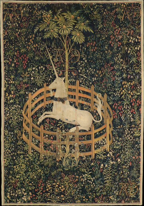 A medieval tapestry depicting a white unicorn enclosed in a circular wooden fence, surrounded by a dense millefleurs floral background.