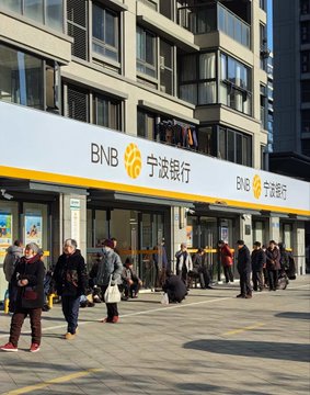 A crowd queues outside a large Ningbo Bank branch, with “BNB” branding beside the Chinese text “宁波银行” displayed prominently across the facade. The long line and prominent crypto-style “BNB” logo visually support the post’s joke that the bank’s sign looks like it is promoting BNB and has gone viral.