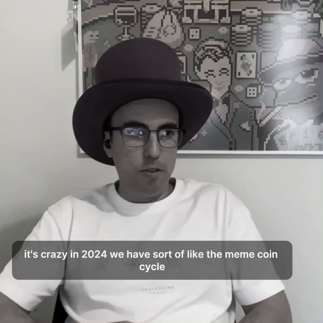 The image features a man wearing glasses and a hat sitting down. The caption of the image reads "Jacek from DEGEN reflects on the project's evolution from meme coin to product ecosystem." This suggests that the man might be discussing or reflecting upon the development of the meme coin, which has evolved into various products over time.