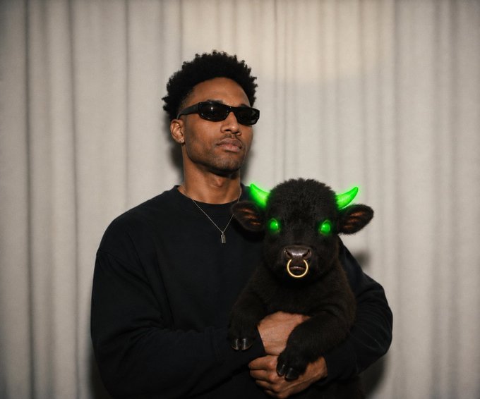 A man wearing black sunglasses and a black sweater holds a black calf with glowing green horns and eyes, fitting a "dev for dev" Halloween costume where they both portray demonic, otherworldly figures.