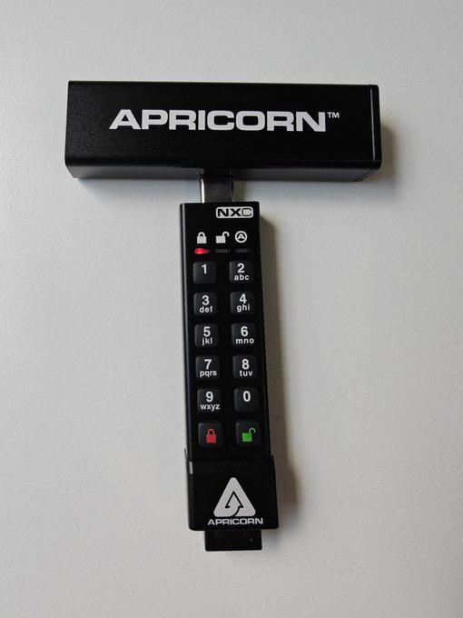 An Apricorn NXG USB drive with a PIN pad encryption keypad is shown, tagged with @apricorn_info and @COLDCARDwallet, highlighting its use as a secure, paranoid-geek backup solution for cold storage of codebases.