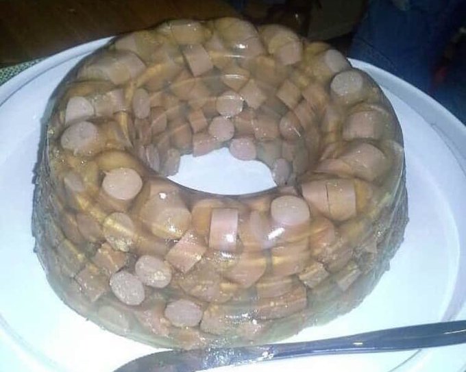 Homemade bundt cake shaped like a ring, filled with banana slices and topped with glazed marshmallows on a white plate.
