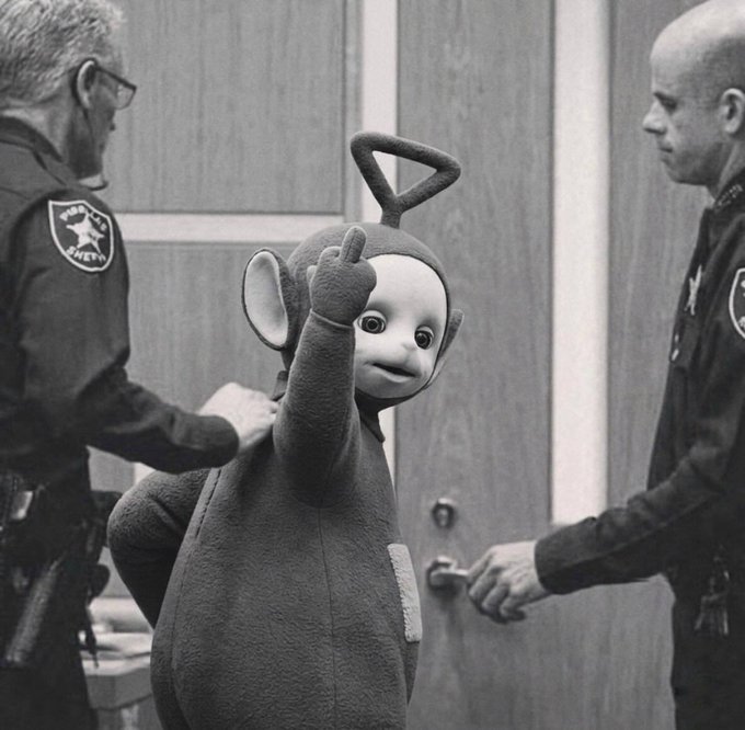A grayscale photo of the Teletubbies character Po being led away by two sheriff's deputies, captioned to celebrate the arrest of a crypto hacker who allegedly stole over $900k, with the wallet address 0x146AD3f87ec31202c9636E28333945A5B041716E listed for the upcoming "injection" of recovered funds.