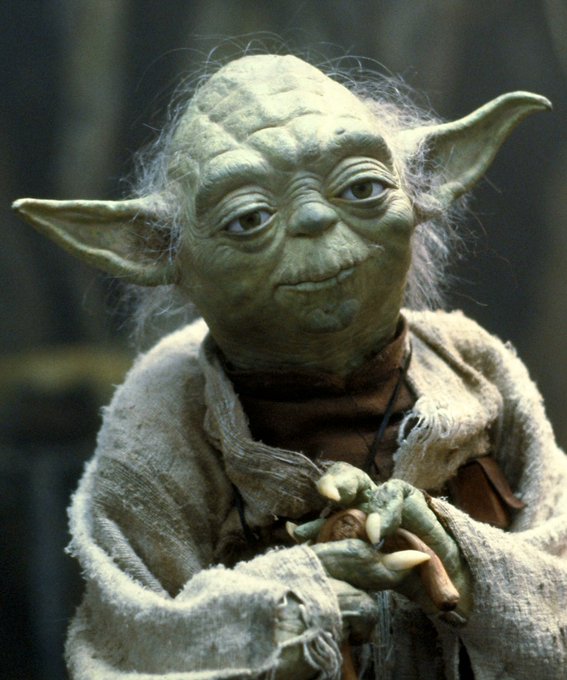The image shows Yoda, the wise green Jedi Master from Star Wars, sitting contemplatively with his hands clasped. The caption connects to his famous wisdom about patience, emphasizing the post's message that perseverance and time make one's goals inevitable and unshakable.