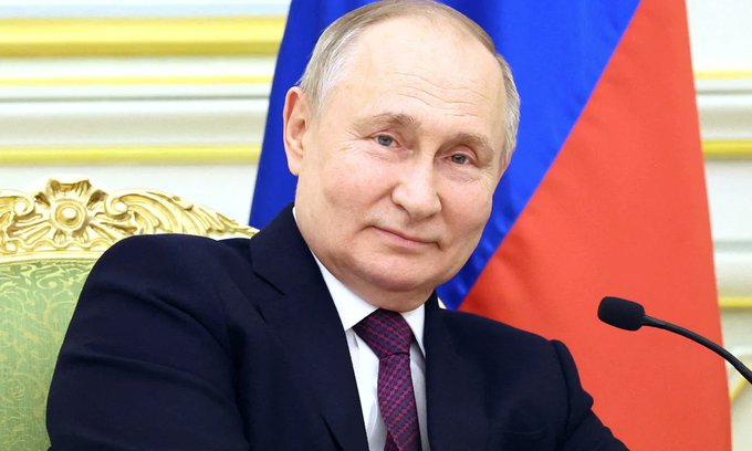 Russian President Vladimir Putin sits in front of the Russian flag, providing a visual subject for the news regarding the State Duma's passing of new crypto regulation legislation requiring his approval.