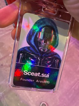 A holographic ID badge displaying "Sceat.sui" as "Founder, AresRPG" with a futuristic helmeted figure, held in someone's hand.