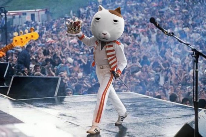 The image shows a large cat mascot costume dressed in a white uniform with red stripes, performing on stage while holding up a crown and a scepter, evoking a regal "queen" persona. This connects to the "$KET to billions" post by visually portraying the feline-themed meme token ($KET) as royalty destined for massive valuation.
