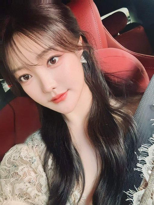 A young woman with long dark hair and a white lace top poses for a selfie inside a car with red leather seats. The image accompanies a post reflecting on X Layer's rapid growth, with the personal photo contrasting against the technical discussion of blockchain trading volumes.