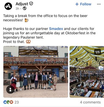 The image shows a LinkedIn post from Adjust highlighting their team at Oktoberfest, with a caption thanking partner Smadex and clients for a successful event at the "Paulaner tent," alongside a photo of the team in traditional Bavarian attire and a view of the packed beer tent interior. While the post celebrates Adjust's brand engagement, it visually reflects the $APP and $EVC partnership mentioned, suggesting collaborative business activity between the two companies.