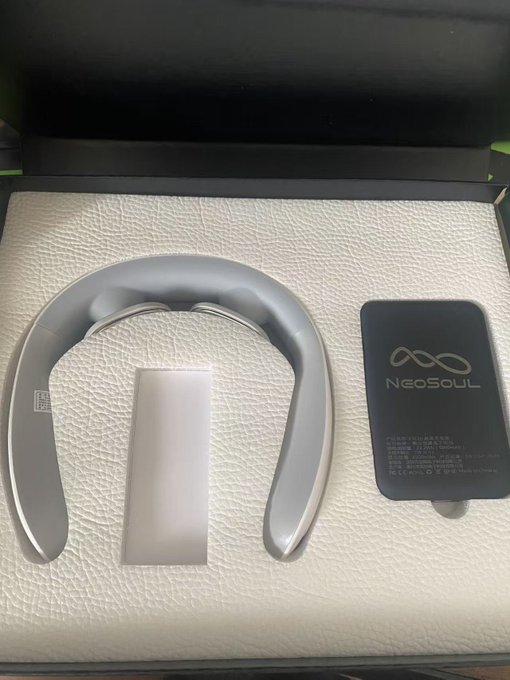 A sleek gray neck and shoulder massager sits in its presentation box alongside a black NeoSoul-branded power bank, showcasing the peripheral gifts received from Miss Pudding (@Rhea0xWeb3) to celebrate NeoSoul's successful $11 million Series A funding round.