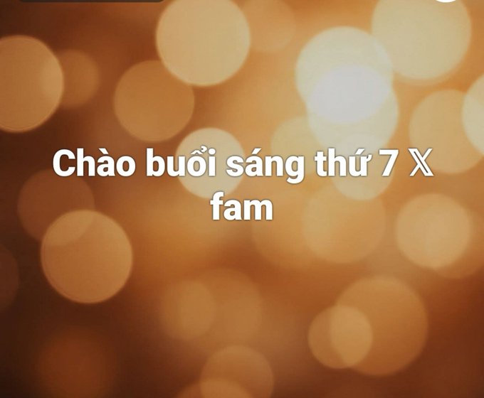 A warm, orange bokeh background with white text reading 'Chào buổi sáng thứ 7 X fam' (Good morning Saturday X fam in Vietnamese).