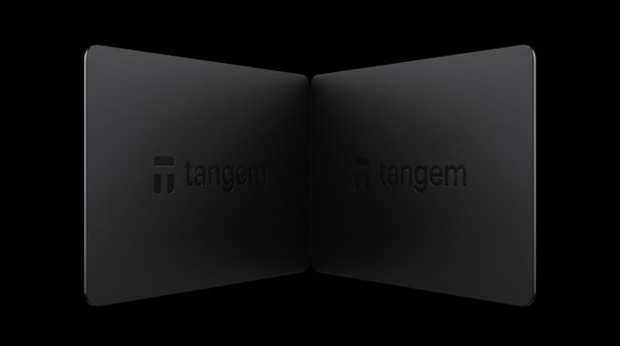Two black devices with the 'tangem' logo displayed on their surfaces, shown opened like a book against a dark background.
