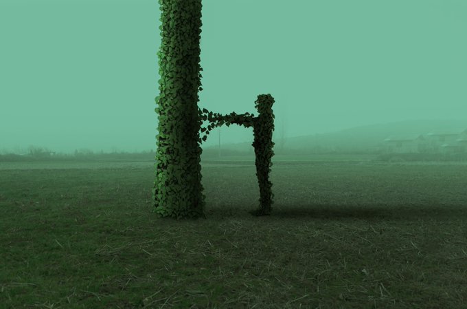 A green-tinted, atmospheric image shows a large pillar and a smaller cross-shaped structure covered in vines, standing in a field with a misty, green sky.