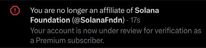 The image displays a notification stating "You are no longer an affiliate of Solana Foundation (@SolanaFndn)" and that the user's account is under review for premium subscriber verification. This directly relates to the accompanying post as it suggests corporate issues with the user's previous post might have led to this affiliation change.