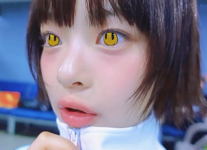 A close-up shot of a young woman with a short brown bob, wearing a white zip-up jacket, features cartoon-style smiley face eyes edited over her actual eyes. The post's caption "milady is just starting" pairs with the image to suggest her innocent, anime-inspired appearance is just the beginning of a transformation or aesthetic.