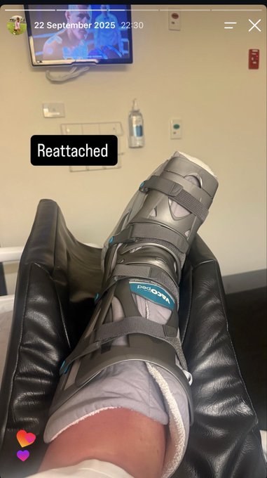 A first-person view of a leg in a gray medical walking boot with 'VeroPed' branding, resting on a black leather surface in what appears to be a medical room; a Snapchat overlay shows the date '22 September 2025' and the text 'Reattached'.