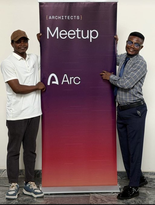 Two men pose smiling on either side of a purple-to-red gradient banner reading "{ ARCHITECTS } Meetup" with the Arc logo, representing the Arc developers meetup event. The image visually reinforces the post by showcasing attendees at the Arc builders gathering.
