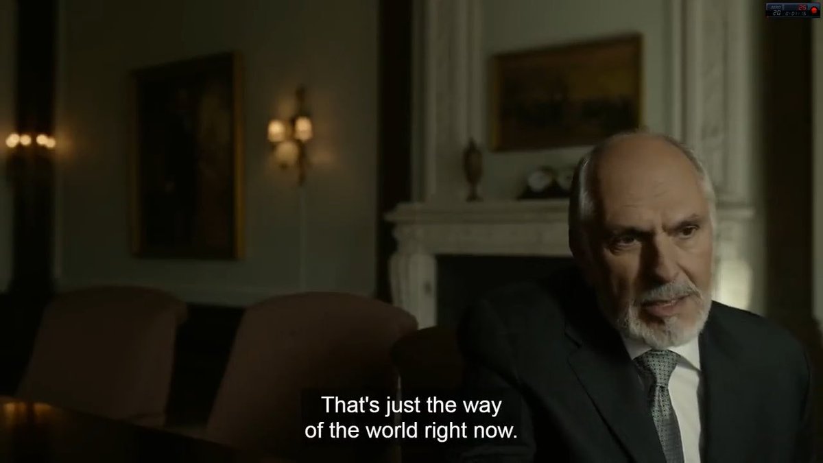 A dimly lit film or TV scene shows an older man in a suit speaking, with the subtitle “That’s just the way of the world right now.”