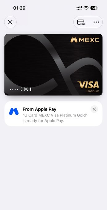 The image displays a sleek black MEXC Visa Platinum card on a smartphone screen, with an Apple Pay notification confirming "U Card MEXC Visa Platinum Gold is ready for Apple Pay," relating to the post about successfully receiving a test qualification for MEXC's new card and showcasing its stylish design.
