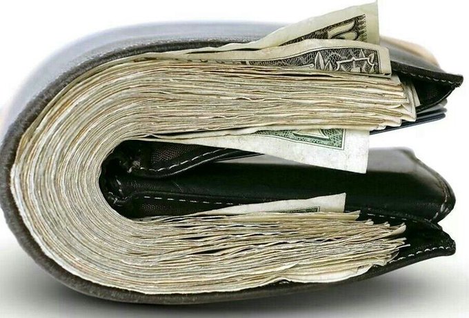 A worn, overstuffed black leather wallet crammed full of U.S. dollar bills bulges at the seams, fitting the post's "in September, our wallet" comment to suggest finances are stretched thin.