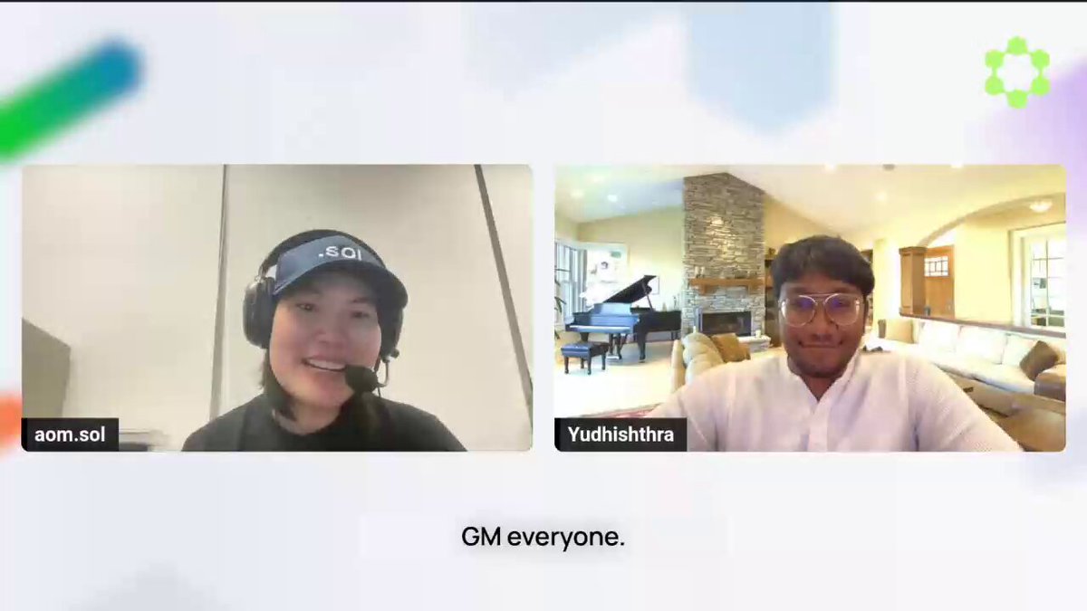The image shows two people having a video call using an app like Zoom or Skype. They are both wearing headphones, which suggests that they might be participating in a group meeting or conference call. The person on the left side of the screen has their face visible, while the other person is partially obscured by the camera angle. Both individuals appear to be engaged in the conversation and focused on each other.