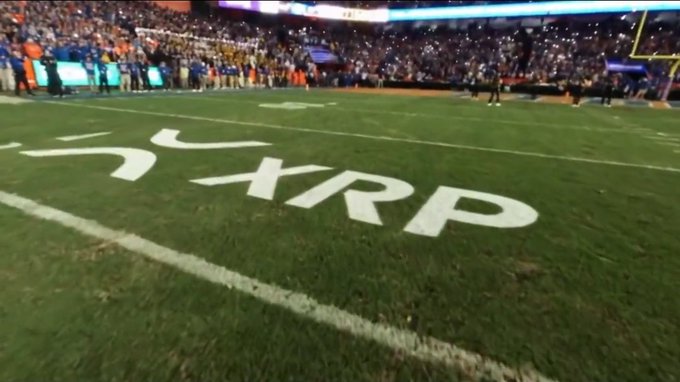 Goosebumps as XRP takes center stage on the football field, with the iconic logo painted boldly on the grass before a packed stadium crowd, marking a major sponsorship moment for the @FloridaGators.