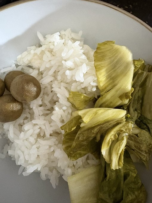 The image shows a bowl of rice with some green vegetables mixed in, including lettuce and possibly other greens or sprouts. The bowl appears to be white, which contrasts nicely with the colorful contents inside. There are also several small brown objects scattered around the bowl, adding an interesting visual element to the scene. The post seems to be about food, as it mentions that "market's eating it up like that today @wallchain @quipnetwork". This suggests that there might have been a recent market event or promotion involving these vegetables and rice, which has attracted people's attention and interest in trying out the dish.
