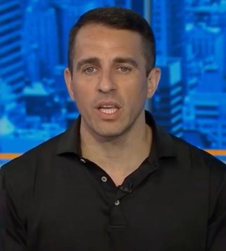 A news anchor in a black polo shirt appears to be speaking on a television broadcast with a blue cityscape background.