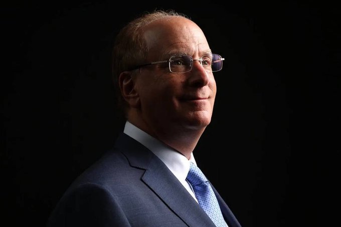 A professional portrait photograph shows a middle-aged man wearing glasses, a dark blue suit, white shirt, and light blue patterned tie, posed against a black background. The accompanying post suggests he may be a financial expert or Wall Street figure being referenced in the discussion of significant Bitcoin ETF inflows of $730.87 million, marking one of the largest buying events of 2026.