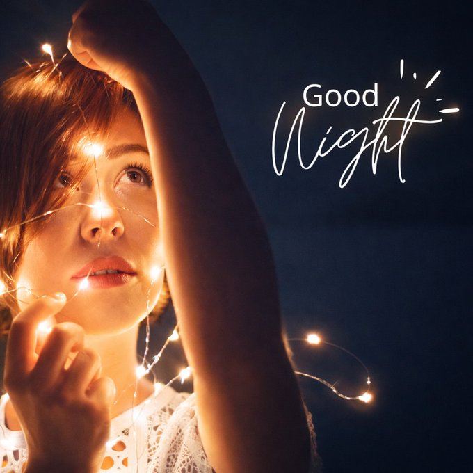 A young woman holds glowing fairy lights near her face against a night sky background, with "Good Night" written in elegant script.