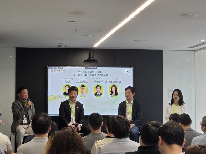 A panel discussion with five speakers seated on stage in front of a screen titled 'bitcoinAsia' and 'OSL', discussing Hong Kong's potential as a stablecoin hub, with the audience visible in the foreground.