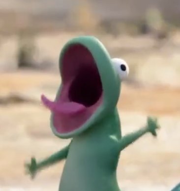 A green claymation-style frog figure with bulging eyes, a wide open mouth, and a pink tongue sticking out stands with its arms raised in a barren landscape.