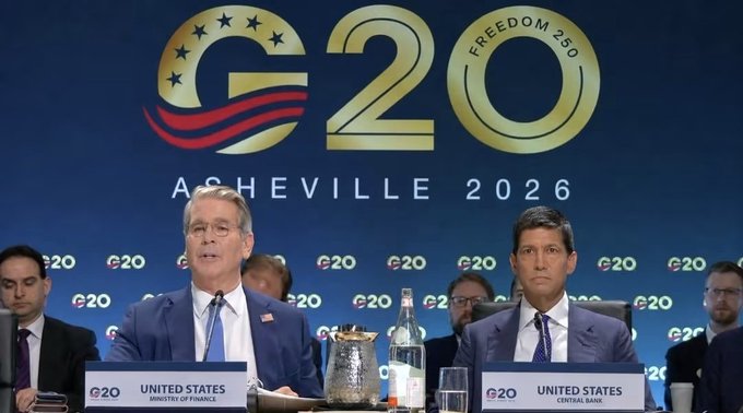 U.S. Treasury Secretary Scott Bessent (left) sits beside Federal Reserve Chair Kevin Warsh at the G20 Finance Ministers and Central Bank Governors meeting in Asheville, where the backdrop reads "G20 ASHEVILLE 2026" and "FREEDOM 250," corresponding to today's G20 Presidency Statement that acknowledged the potential of digital assets.